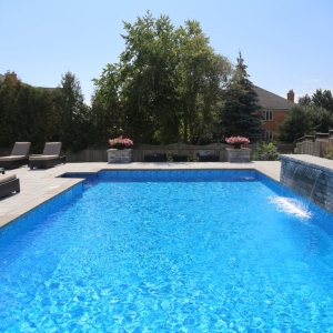 pool surrounded by interlocking stone patio