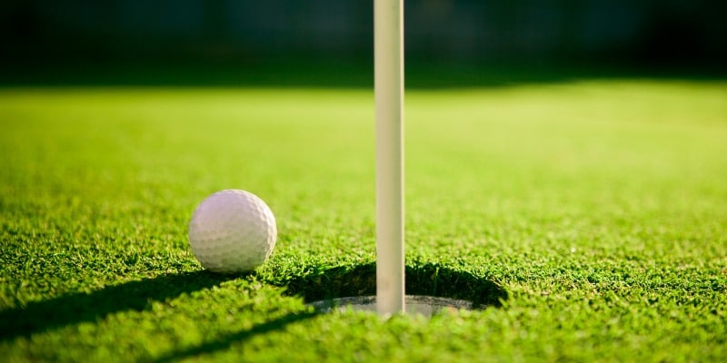 Golf ball on golf green near hole