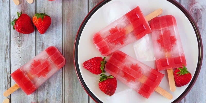 Canada day popsicles and strawberries on a plate