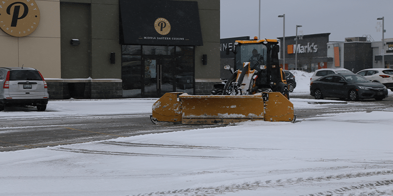 Snow plows removing snow in parking lot