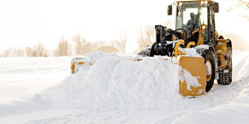 Snow plow pushing snow pile